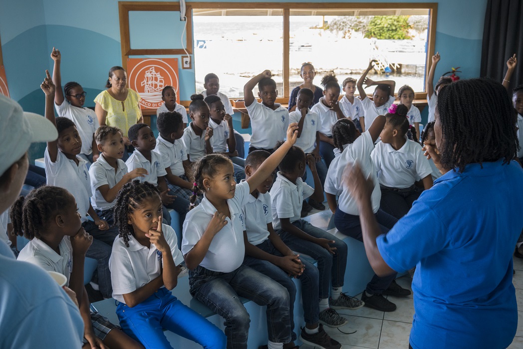 Banco di Caribe ta adoptá 5 klas di 5 skol básiko pa proyekto ‘Bayena i Dòlfein’ di Dolphin Academy