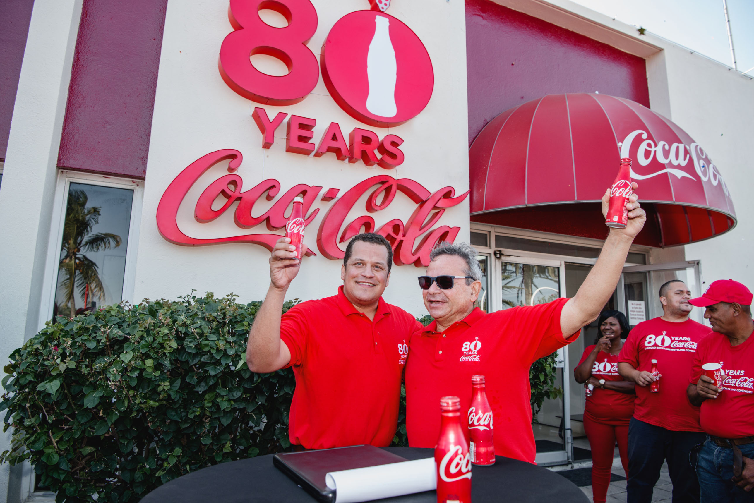 CURAÇAO BEVERAGE BOTTLING COMPANY I COCA-COLA TA INISIA SELEBRASHON 80 AÑA NA KORSOU