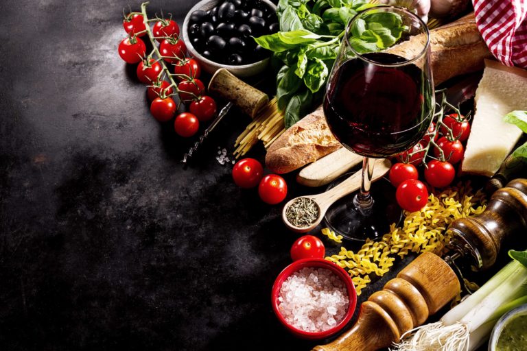 Tasty fresh appetizing italian food ingredients on dark backgrou