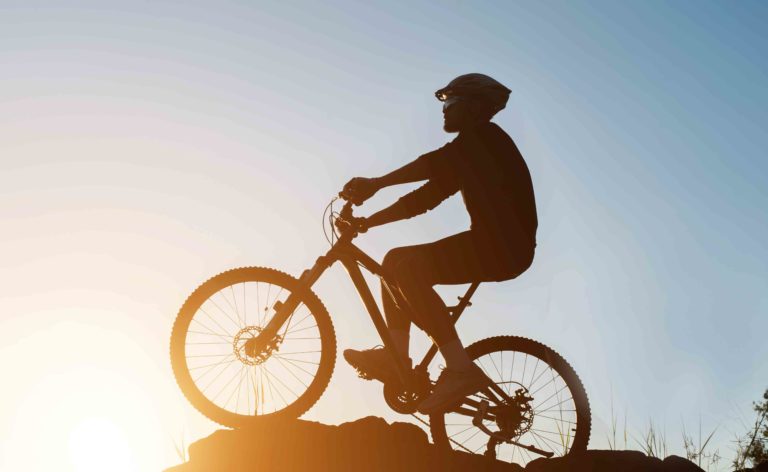 Silhouette of a man on mountain-bike during sunset.